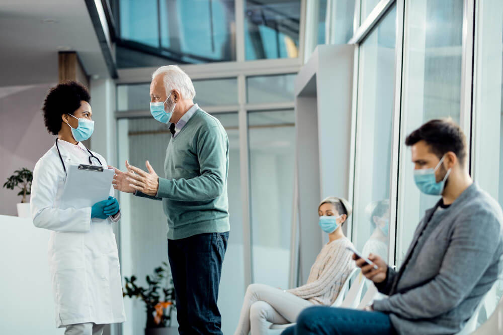 senior-man-african-american-doctor-wearing-face-masks-while-talking-hospital